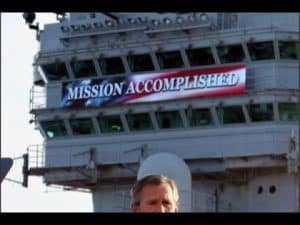 President George W. Bush on aircraft carrier, "Mission Accomplished" banner visible. Illustrates the Bush Doctrine.