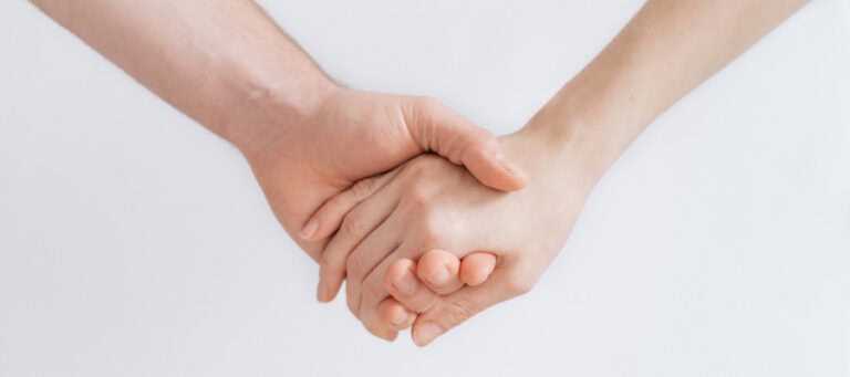 Two hands clasped together, symbolizing support and connection.