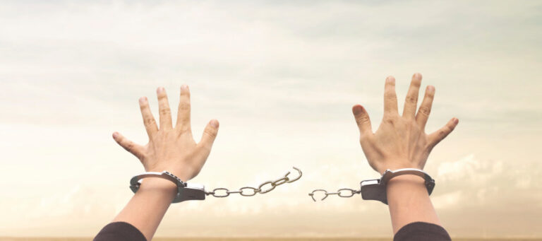 Hands reaching upward, connected by a broken chain of handcuffs, symbolizing freedom from cosmetic neurology's constraints.