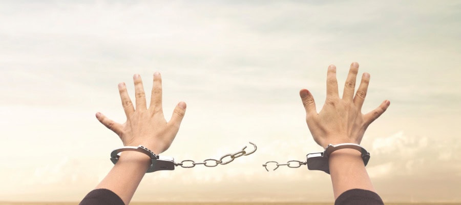 Hands reaching upward, connected by a broken chain of handcuffs, symbolizing freedom from cosmetic neurology's constraints.