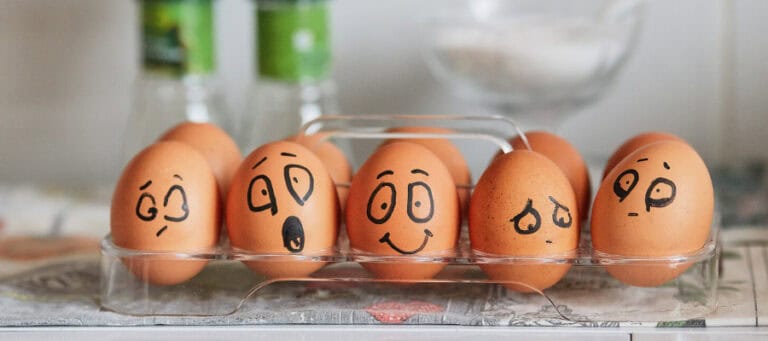Eggs with drawn-on faces expressing various emotions. Illustrates evolutionary psychology concepts.