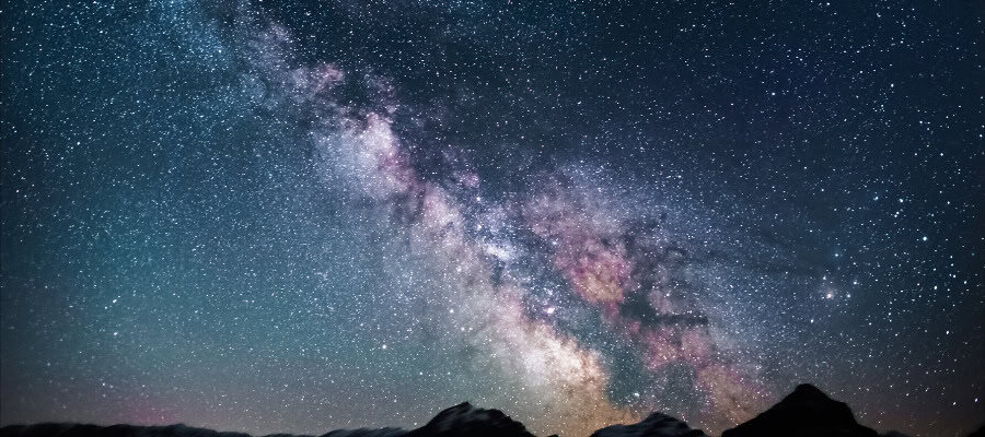 Majestic Milky Way galaxy over silhouetted mountains at night. A stunning view of God's design in nature.