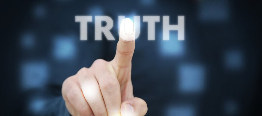 Fingertip touching "TRUTH" on a digital screen; discerning truth from falsehood.