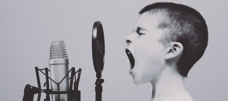 Boy yelling into microphone, expressing truth or falsehood.