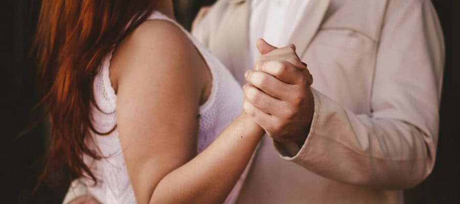 Close-up of a couple holding hands, symbolizing connection and trust.