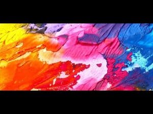Abstract painting in vibrant colors; reds, pinks, blues, and yellows. Explores the definition of art.