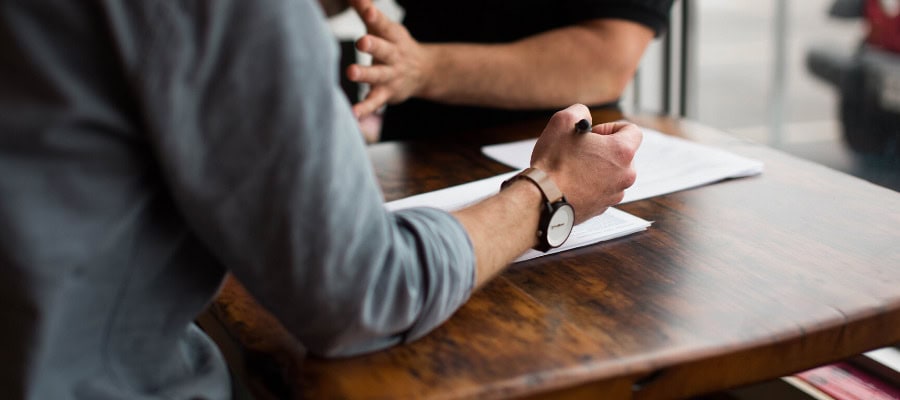 Two people in discussion, one writing notes.