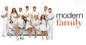 The cast of Modern Family in white outfits, holding ice cream cones.