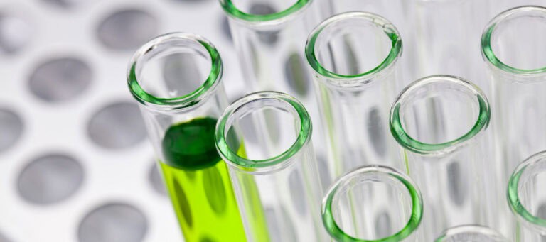 Close-up of test tubes containing a green liquid.