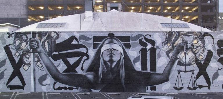 Blindfolded woman holding scales of justice and sword, symbolizing disagreement.