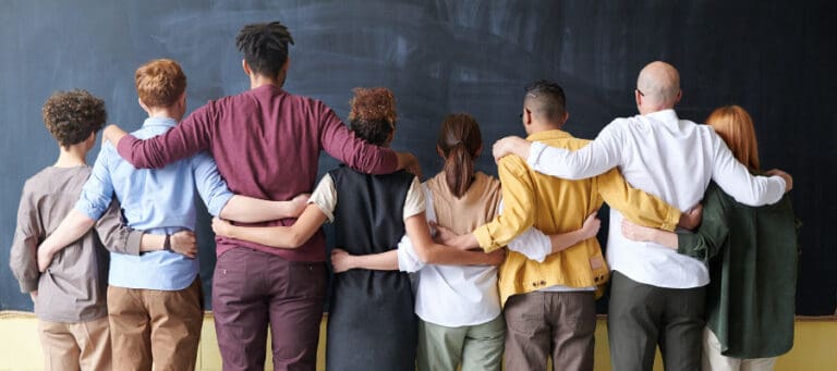 Diverse group of people embracing, showing unity and support.