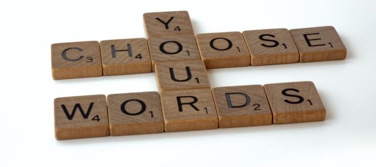 Scrabble tiles spelling "Choose Your Words," illustrating the search for meaning in life.