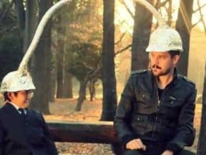 Two men wearing tinfoil hats with long antennas, possibly illustrating mind reading.