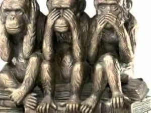 Three wise monkeys: one covering its eyes, one its ears, and one its mouth. Self-deception concept.