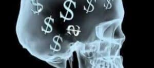 X-ray of a skull filled with dollar signs, illustrating the concept of economics as a potential obsession.