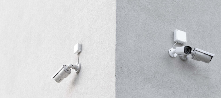 Two security cameras mounted on a building's exterior wall.