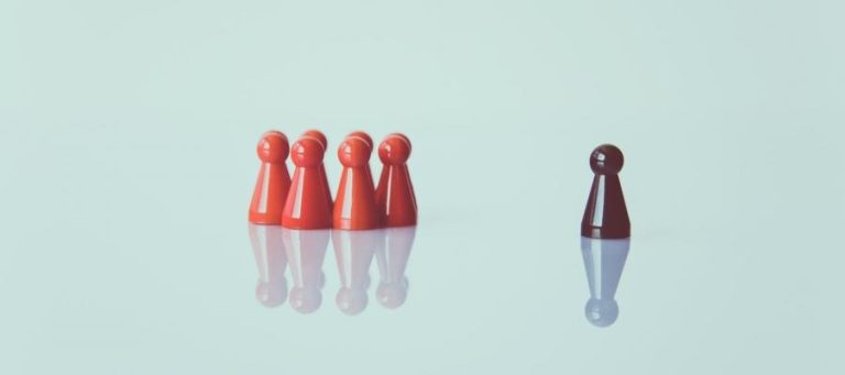 Five red game pieces and one black game piece on a light blue background. Represents differing perspectives.