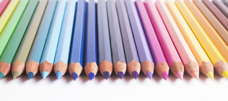 Colored pencils arranged in a row, showing a spectrum of colors.