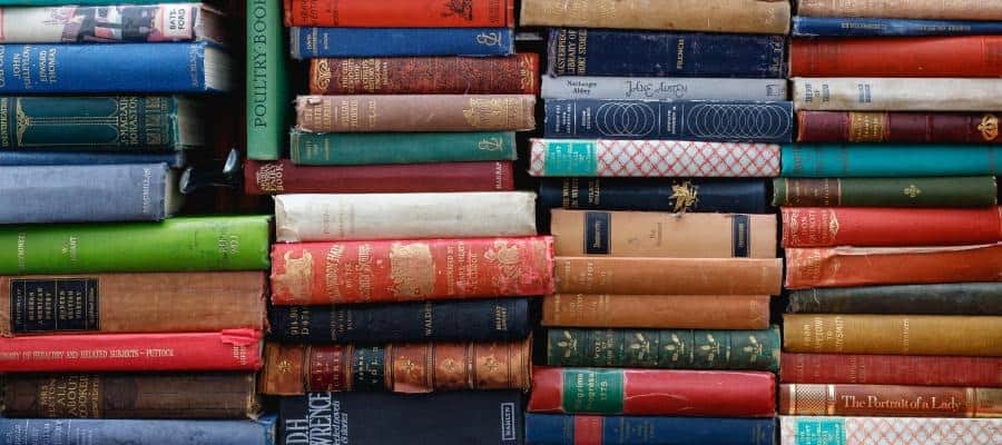 A stack of vintage books, showcasing a variety of titles and authors.