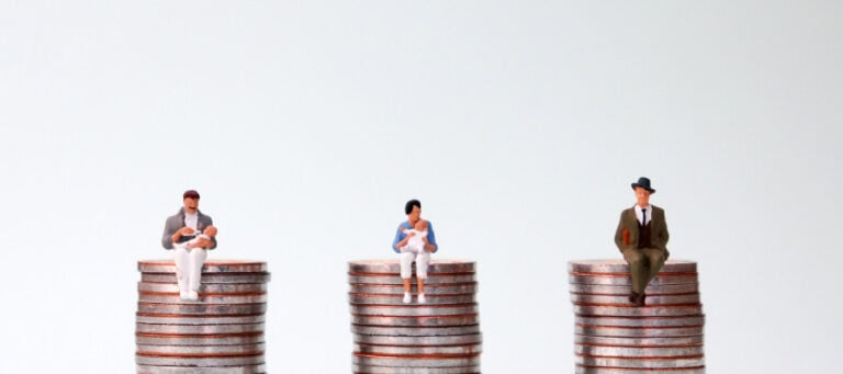 Miniature figures representing families and a single man atop stacks of coins, illustrating economic disparity.