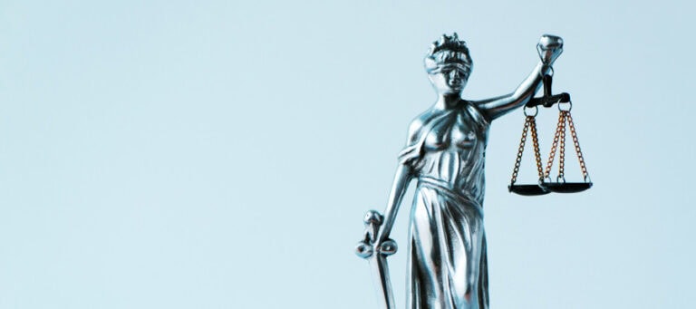 Silver Lady Justice statue holding scales of justice