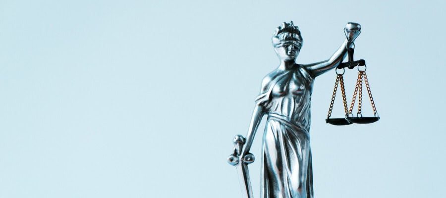 Silver Lady Justice statue holding scales of justice