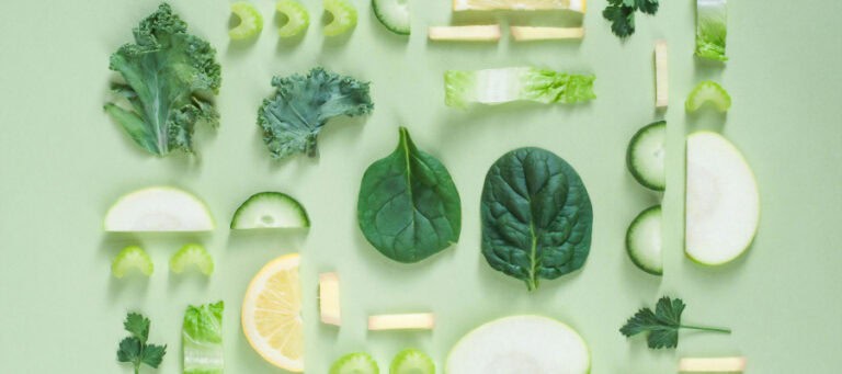 Assorted green vegetables and lemon slices arranged on a green background.