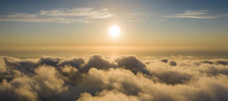 Golden sunset viewed from above a sea of clouds.