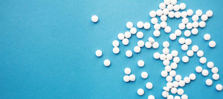 White pills scattered on a blue background