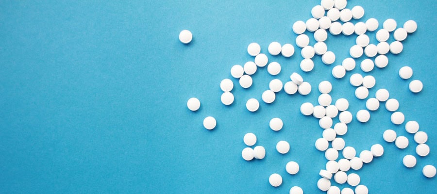 White pills scattered on a blue background