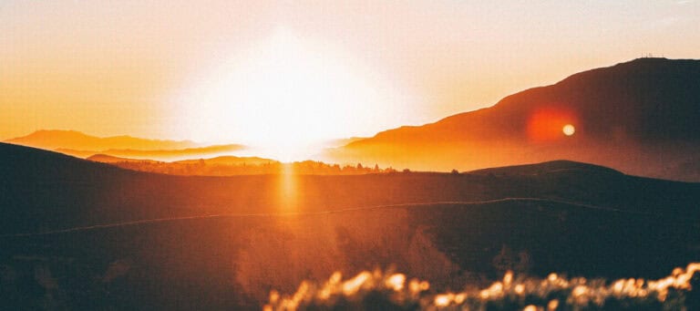 Sunset over rolling hills and valleys.