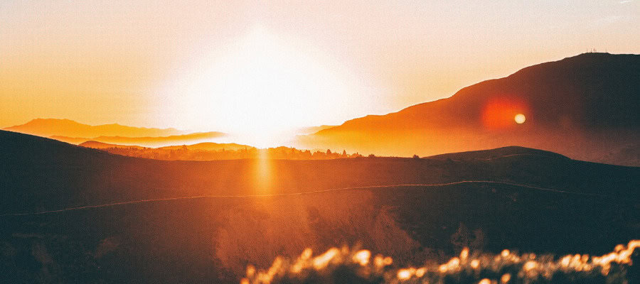 Sunset over rolling hills and valleys.