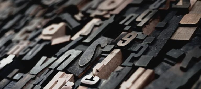 Close-up of vintage printing blocks, showcasing various letters and numbers.