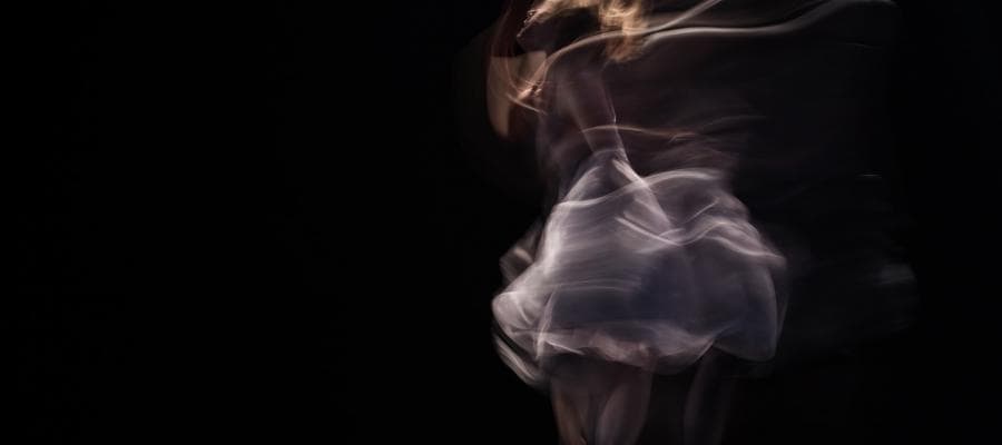 Motion-blurred ballerina in a flowing tutu, expressing dance as a way of knowing.