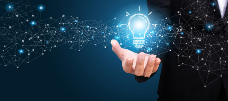 Person's hand holding a glowing lightbulb icon, surrounded by a network of connections.