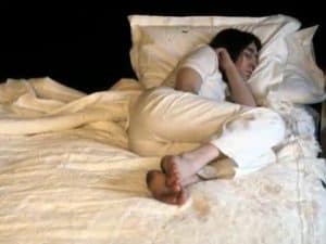 Person sleeping peacefully in bed, showcasing the philosophy of sleep.