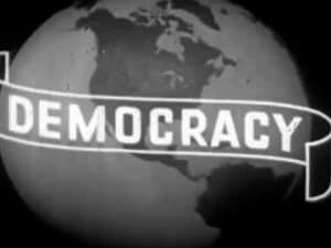 Black and white image of a globe with the word "DEMOCRACY" on a banner.
