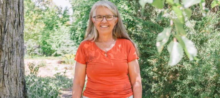 Woman with gray hair smiling outdoors