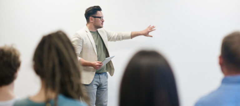 Man giving a presentation to a diverse audience.