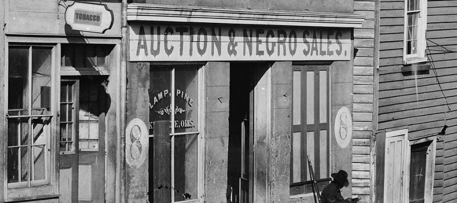 19th-century storefront with "Auction & Negro Sales" sign.