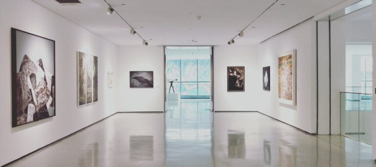Modern art gallery interior with paintings and sculpture.