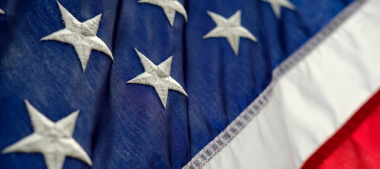 Close-up of a US flag, showing stars and stripes.