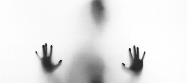 Blurred figure with hands outstretched, symbolizing the complexities of consent.