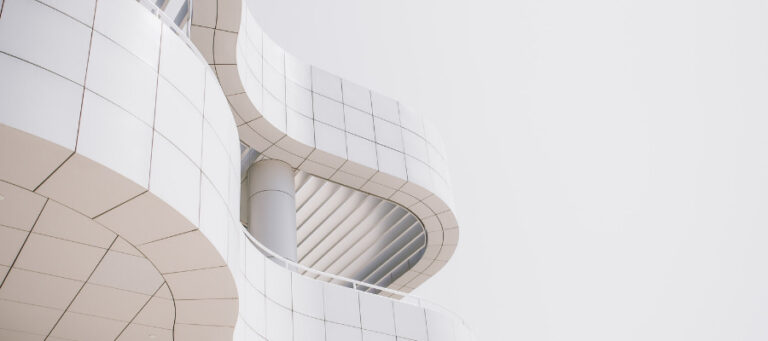 Abstract architectural design of a modern building with curved white walls and a central column.