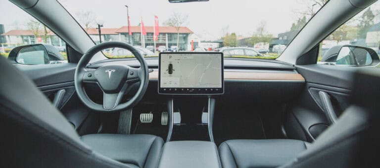 Tesla Model 3 interior with navigation screen displayed.