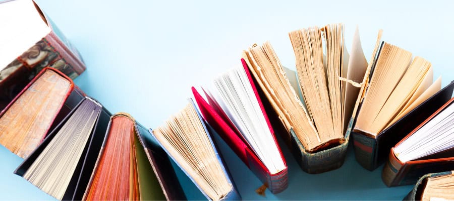 Collection of open books arranged in a curved line on a blue background.