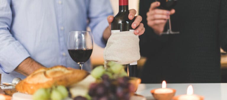Couple enjoying red wine and bread during a romantic dinner.