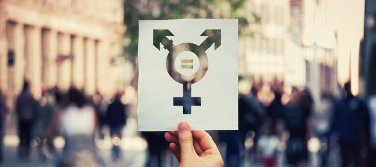 Hand holding paper with transgender symbol.