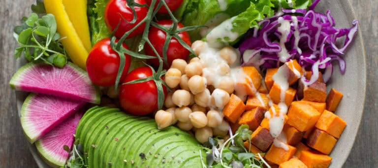 Colorful vegan bowl with chickpeas, sweet potatoes, avocado, and vegetables.