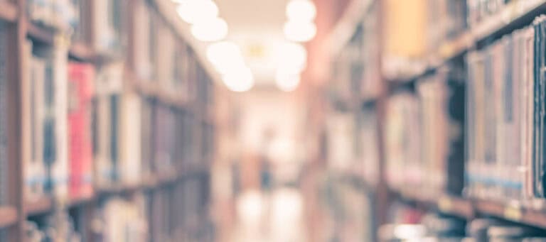 Blurred view of library bookshelves, suggesting the vastness of knowledge and potential for automation in information management.